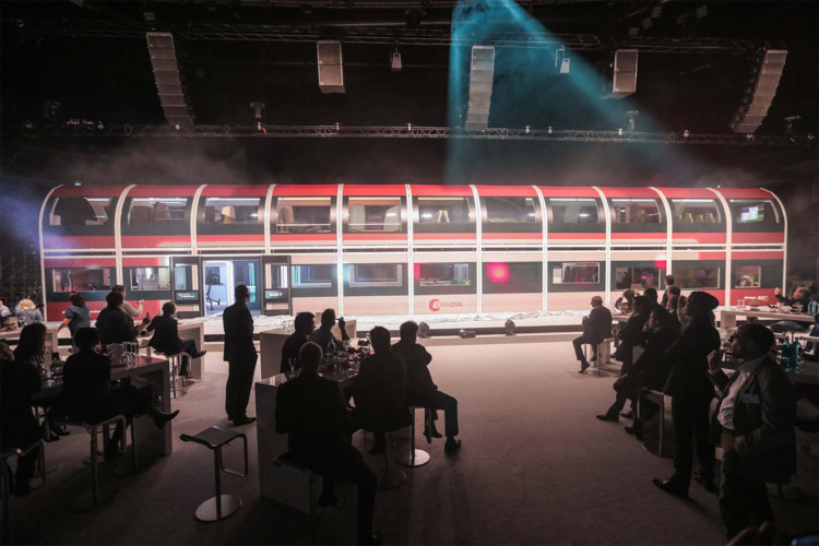 DB Regio Ideenzug: roter Ideenzug der Deutschen Bahn in einem Bahnhof, davor stehen verschiedene Menschen, die sich den Zug anschauen. Projekt von justZARGEScommunicate!