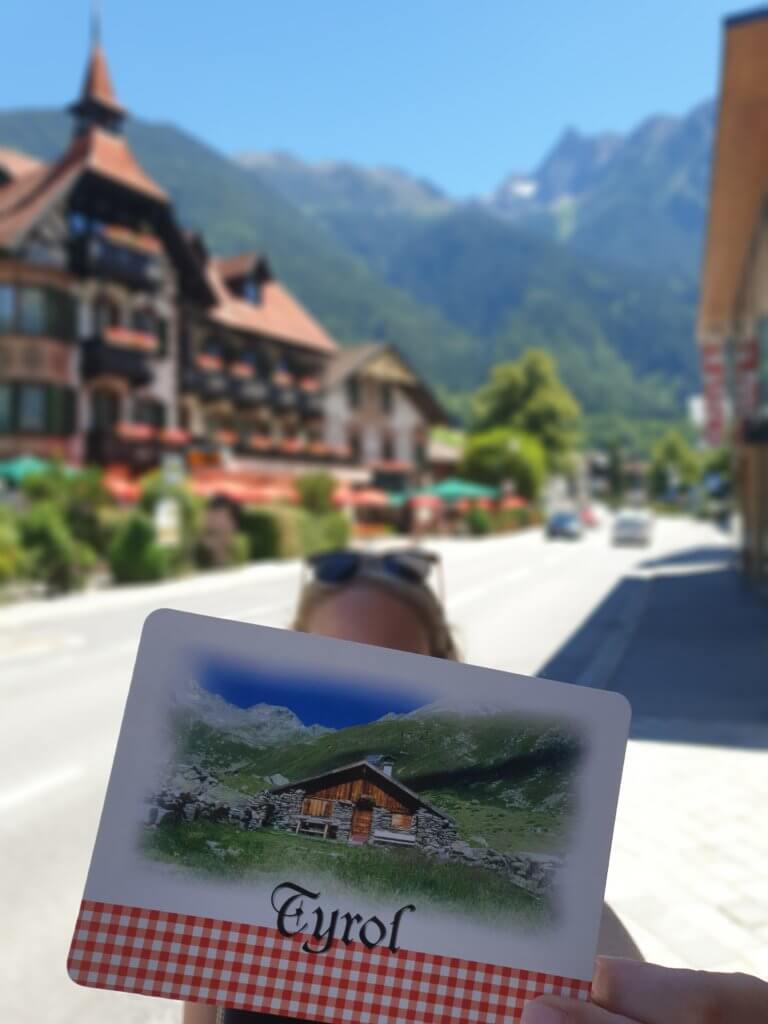 Michaela schreibt Postkarten von ihrem Kurztrip nach Tirol.